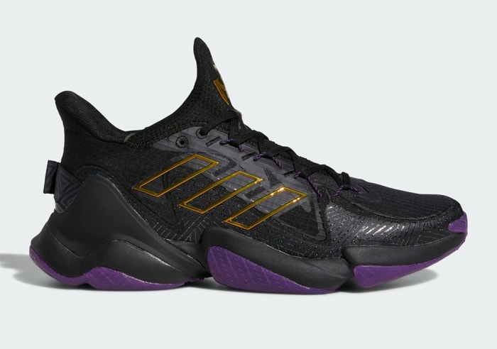 Side view of black and purple Adidas shoe.